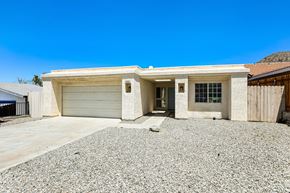 La Quinta house for rent - A house with a garage door and a gravel driveway.