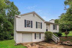 Marietta house for rent - A white house with a grey roof and a white fence.