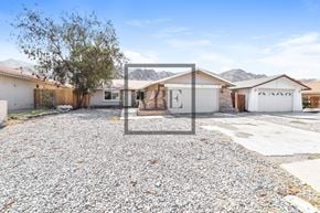 La Quinta house for rent - A gravel driveway leads to a house with a garage and a tree.