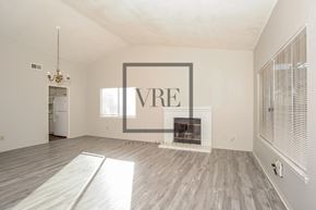 Lancaster house for rent - A large, empty room with a fireplace and a chandelier.