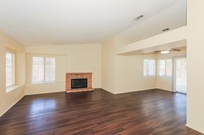 Hemet house for rent - A living room with a fireplace and wood floors.