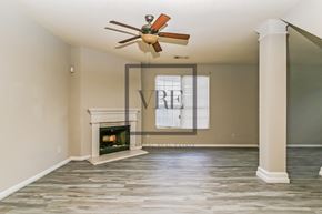 Lithonia house for rent - A spacious room with a fireplace and a fan.