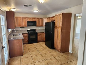 Las Vegas house for rent - A kitchen with black appliances and wooden cabinets.