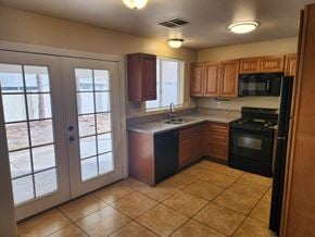 Las Vegas house for rent - A kitchen with black appliances and wooden cabinets.