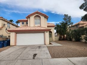 Las Vegas house for rent - A house with a red tile roof and a white garage door.