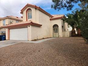 Las Vegas house for rent - A house with a red tile roof and a white garage door.