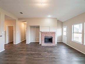 Forney house for rent - A living room with a fireplace and wood flooring.