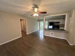 Decatur house for rent - an empty living room and kitchen with a ceiling fan
