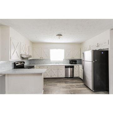 Stone Mountain house for rent - a kitchen with white cabinets and a black refrigerator