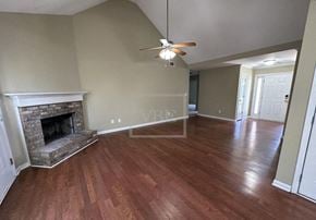 Adairsville house for rent - A living room with a fireplace and wood flooring.