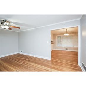 Roswell house for rent - A room with a ceiling fan and wooden floors.