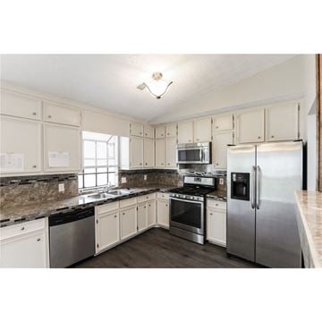 Stone Mountain house for rent - a kitchen with stainless steel appliances and white cabinets