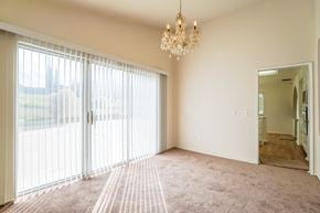 Palmdale house for rent - A room with a chandelier and sliding glass doors.