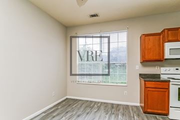 Lithonia house for rent - A kitchen with wooden cabinets and a window with blinds.