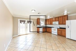 La Quinta house for rent - A kitchen with white appliances and wooden cabinets.