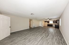 Indio house for rent - A spacious room with wood flooring and a ceiling fan.