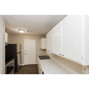 Fairburn house for rent - A kitchen with white cabinets and a black fridge.