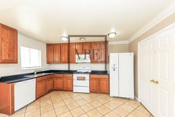 La Quinta house for rent - A kitchen with wooden cabinets and white appliances.