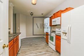 Lithonia house for rent - A kitchen with white appliances and orange cabinets.