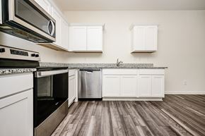 Mcdonough house for rent - A kitchen with white cabinets and a wooden floor.
