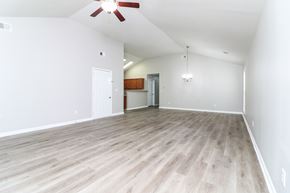 Cartersville house for rent - A room with a ceiling fan and light, hardwood floors, and a doorway leading to another room.