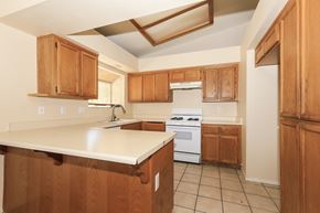 Hemet house for rent - A kitchen with wooden cabinets and a white counter top.