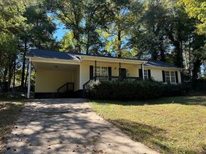 Hiram house for rent - a yellow house with a driveway and trees
