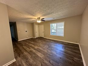 Hiram house for rent - an empty living room with wood floors and a ceiling fan
