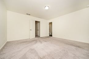 Mcdonough house for rent - A spacious room with carpeted floor and two doors.