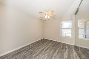 Indio house for rent - A room with a ceiling fan and wood flooring.