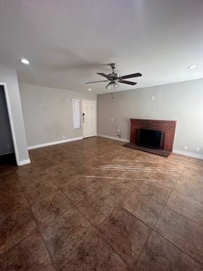 Moreno Valley house for rent - an empty living room with a brick fireplace and a ceiling fan