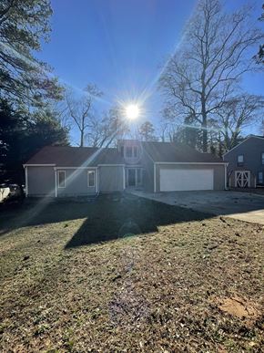 Douglasville house for rent - A house with a garage is bathed in sunlight.