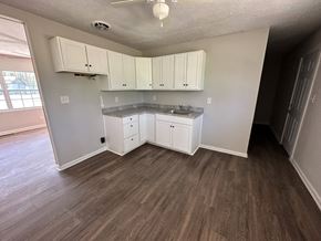 Jonesboro house for rent - A kitchen with white cabinets and a wooden floor.