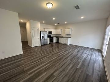 Mcdonough house for rent - an empty living room and kitchen with wood flooring