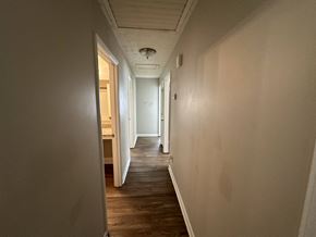 Riverdale house for rent - a hallway with white walls and wooden floors and a ceiling