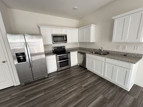 Mcdonough house for rent - a kitchen with white cabinets and stainless steel appliances