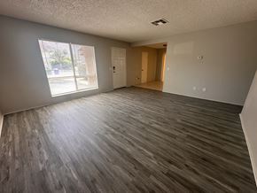 La Quinta house for rent - an empty living room with wooden floors and a window
