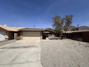 La Quinta house for rent - a house with a gravel driveway and a garage door