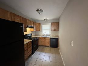 Austell house for rent - an empty kitchen with black appliances and wooden cabinets