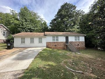 Austell house for rent - a small white and brick house with a driveway and trees