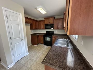 Cartersville house for rent - a kitchen with granite counter tops and wooden cabinets