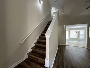 Cartersville house for rent - a view of a staircase in a home with wood floors and white walls