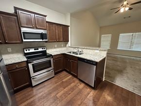 Woodstock house for rent - an empty kitchen with stainless steel appliances and granite counter tops