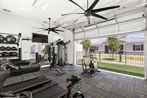Phoenix apartment for rent - a gym with weights and cardio equipment and a large window at Zora Encanto, Phoenix, Arizona