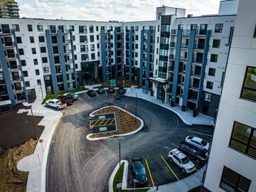 Edmonton apartment for rent - A parking lot in front of a building with cars parked.