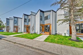 Calgary apartment for rent - A row of modern houses with grey siding and wooden doors.