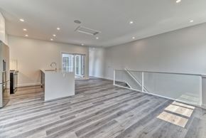 Calgary apartment for rent - A spacious room with wooden flooring and a white counter.