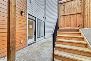 Calgary apartment for rent - A wooden staircase leads to a glass door entrance.