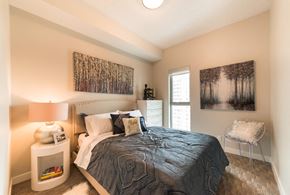 Edmonton apartment for rent - A bedroom with a bed, nightstand, and two pictures on the wall.