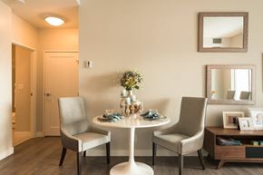 Edmonton apartment for rent - A dining room with a table set for two and a vase of flowers on the table.
